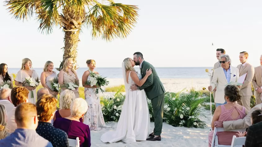 beach wedding ceremony bride and groom kiss at altar overlooking gulf sundial sanibel